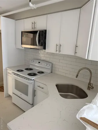 a kitchen with stainless steel appliances granite countertop a sink a stove and microwave