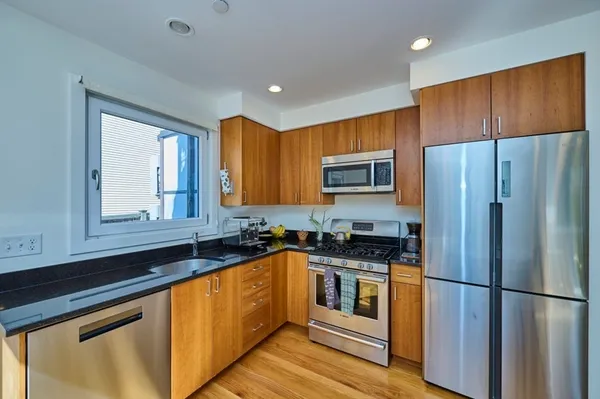 a kitchen with granite countertop stainless steel appliances a refrigerator sink and microwave