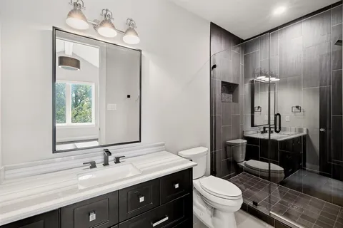 a bathroom with a sink a toilet and a mirror
