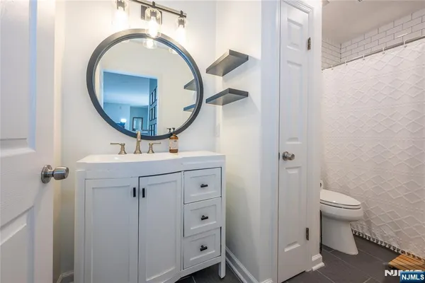 a bathroom with a sink a mirror a toilet and a mirror