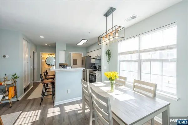 a view of a dining room and livingroom with furniture wooden floor a chandelier