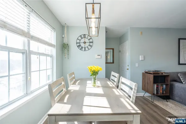 a view of a dining room with furniture a chandelier and wooden floor