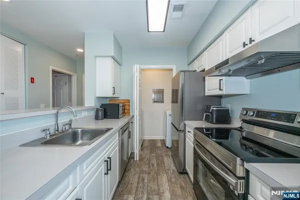 a kitchen with stainless steel appliances a sink stove and refrigerator