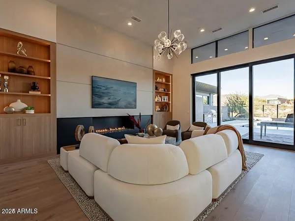 a living room with furniture a large window and a chandelier