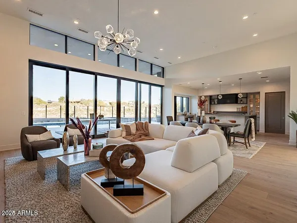 a living room with furniture a chandelier and a large window