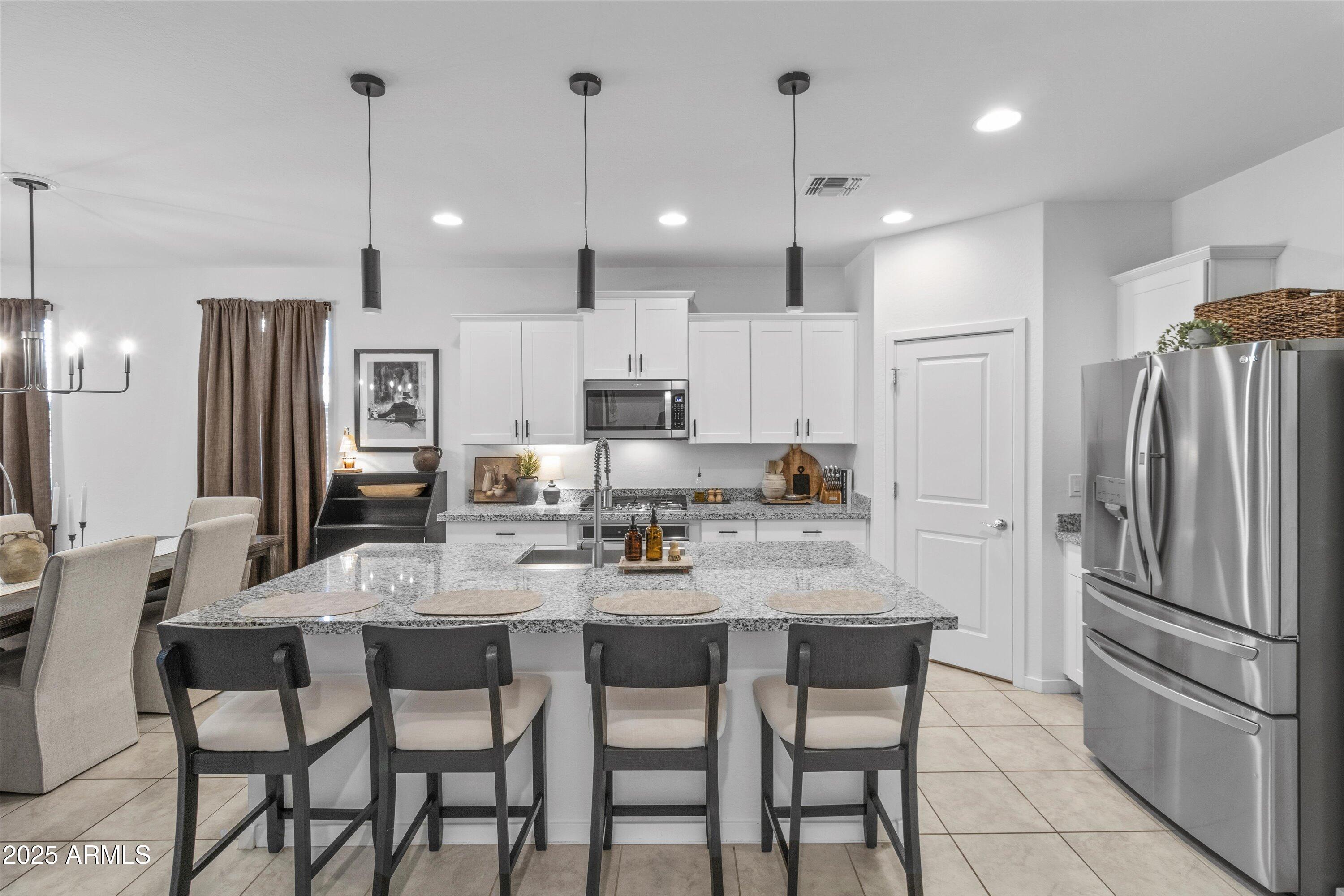 17970 West Pierson Street Goodyear, AZ 85395 - Photo 4 of 66 a kitchen with refrigerator a sink and chairs