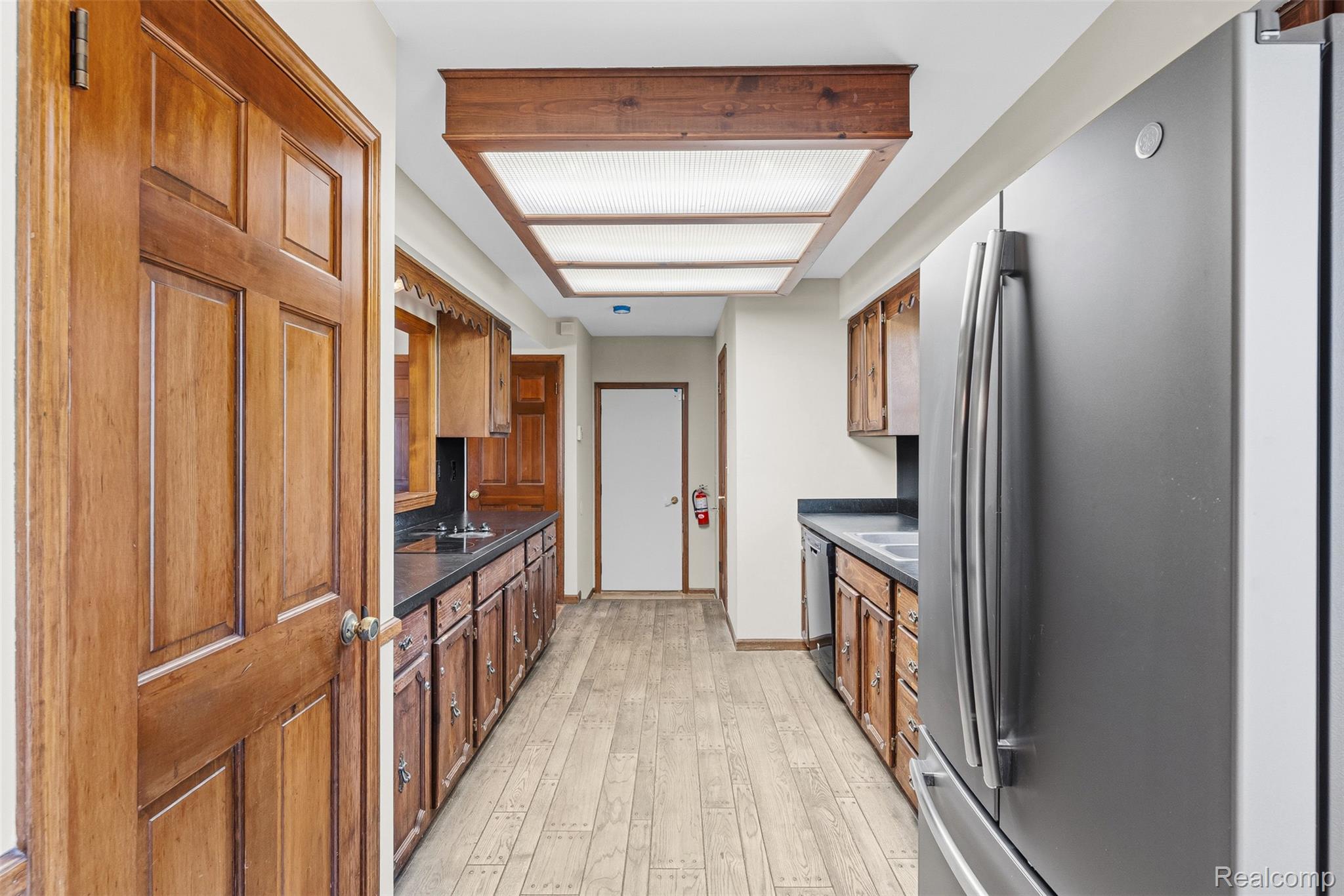 4191 McCandlish Road Grand Blanc, MI 48439 - Photo 20 of 53 Kitchen featuring dark countertops, freestanding refrigerator, light wood-style flooring, and wood finish cabinets