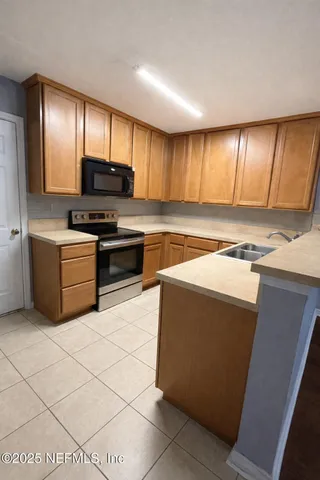 a kitchen with stainless steel appliances a stove a sink and a microwave