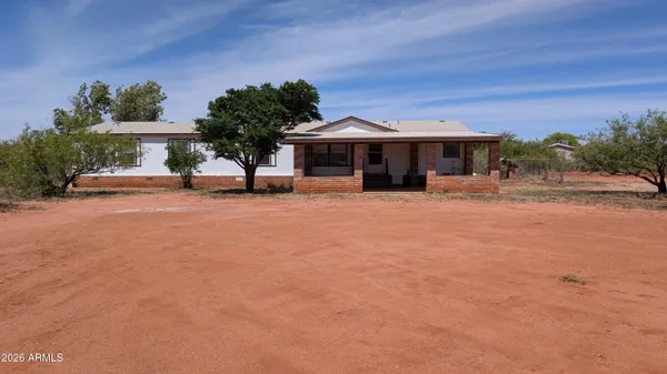 a view of a house with a yard and sitting area