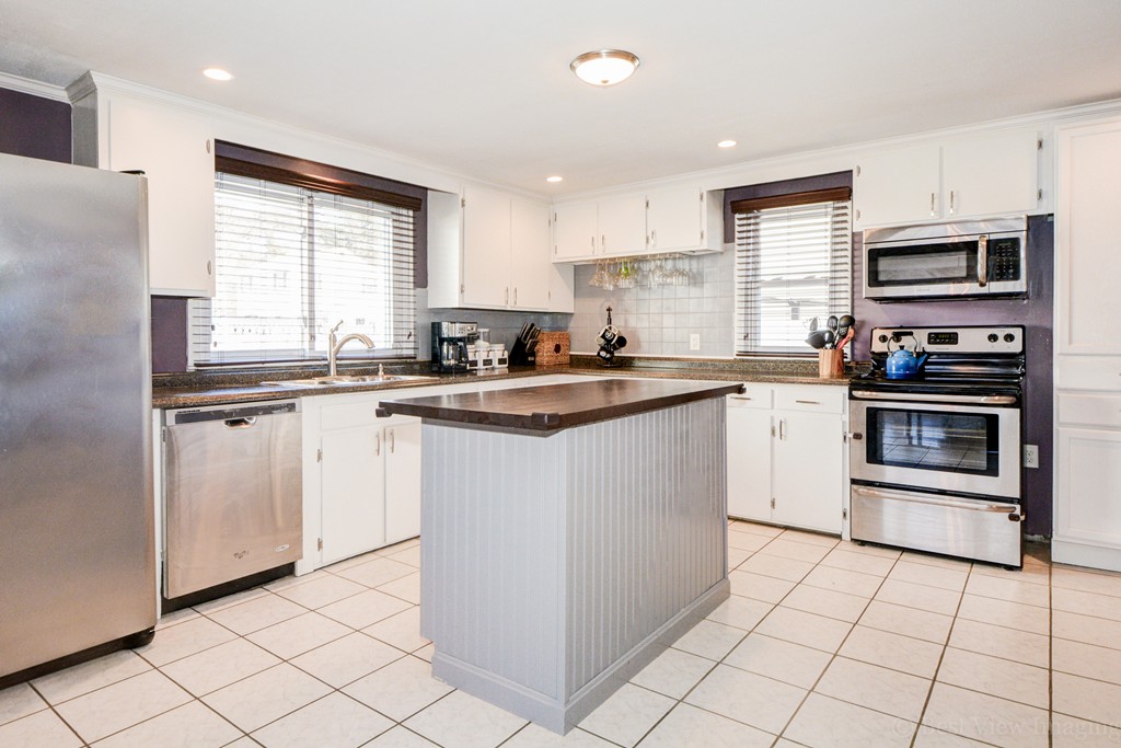 854 Boston Road Billerica, MA 01821 - Photo 12 of 30 a kitchen with stainless steel appliances granite countertop a sink stove a refrigerator a microwave oven and white cabinets