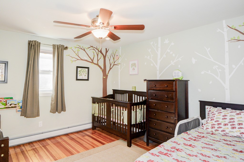 854 Boston Road Billerica, MA 01821 - Photo 20 of 30 a bedroom with a bed and wooden floor