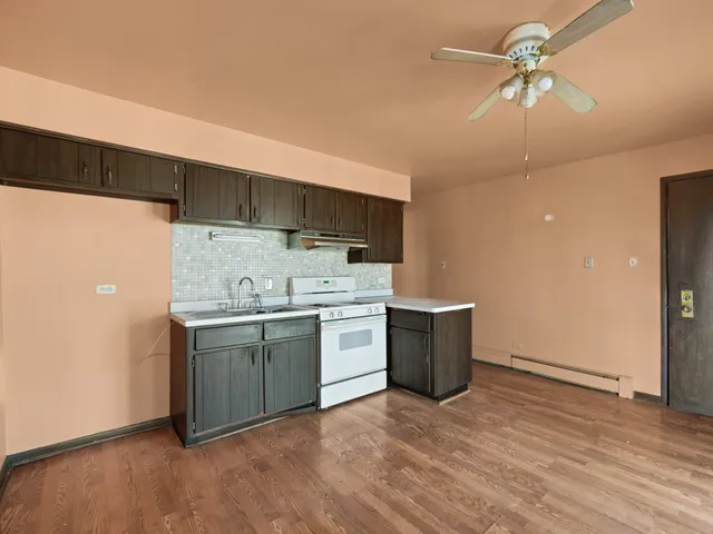 a kitchen with a sink cabinets and wooden floor