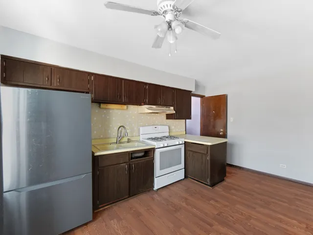 a kitchen with stainless steel appliances a sink a stove a refrigerator and cabinets