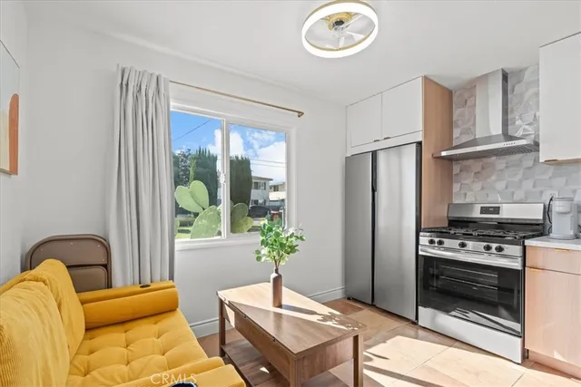 a kitchen with stainless steel appliances granite countertop a stove a refrigerator and a dining table with wooden floor