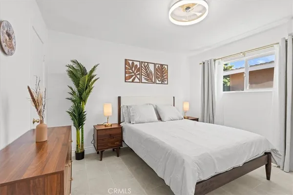 a bedroom with a large bed and a potted plant