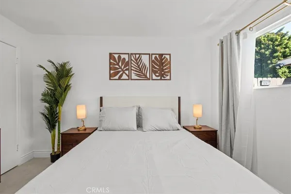 a bedroom with a bed and a lamp on dresser