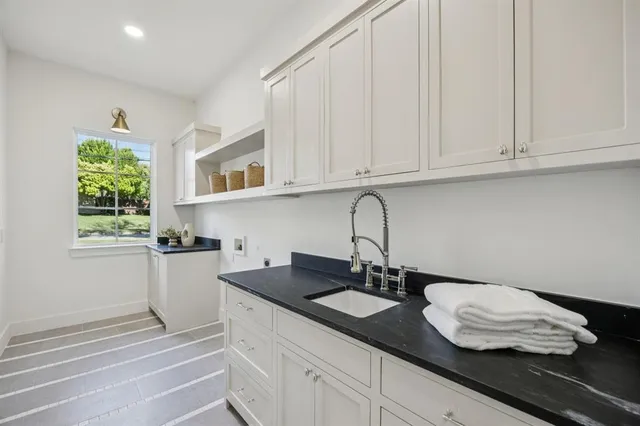 a kitchen with stainless steel appliances granite countertop white cabinets a sink and dishwasher