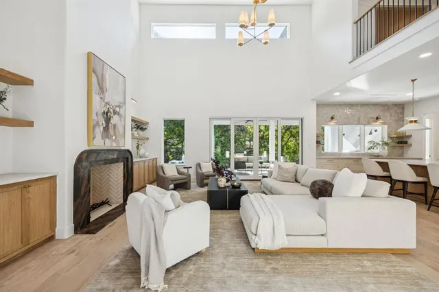 a living room with furniture a large window and a chandelier