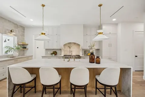 a kitchen with stainless steel appliances granite countertop a kitchen island a table and chairs