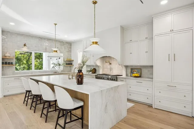 a kitchen with stainless steel appliances a table chairs and a window