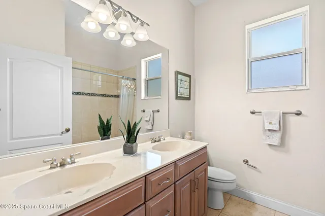 a spacious bathroom with a double vanity sink a mirror and a shower