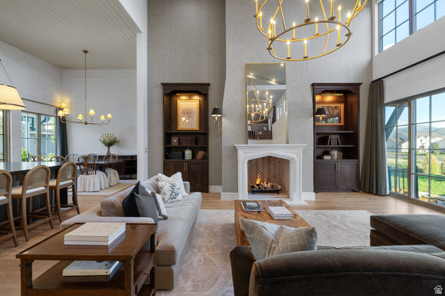 558 West Rheinfalls Circle Midway, UT 84049 - Photo 7 of 61 Soaring two-story great room with coffered ceiling, gas fireplace with white surround and dark wood-finish mantelpiece, and abundant natural light from oversized windows and glass doors