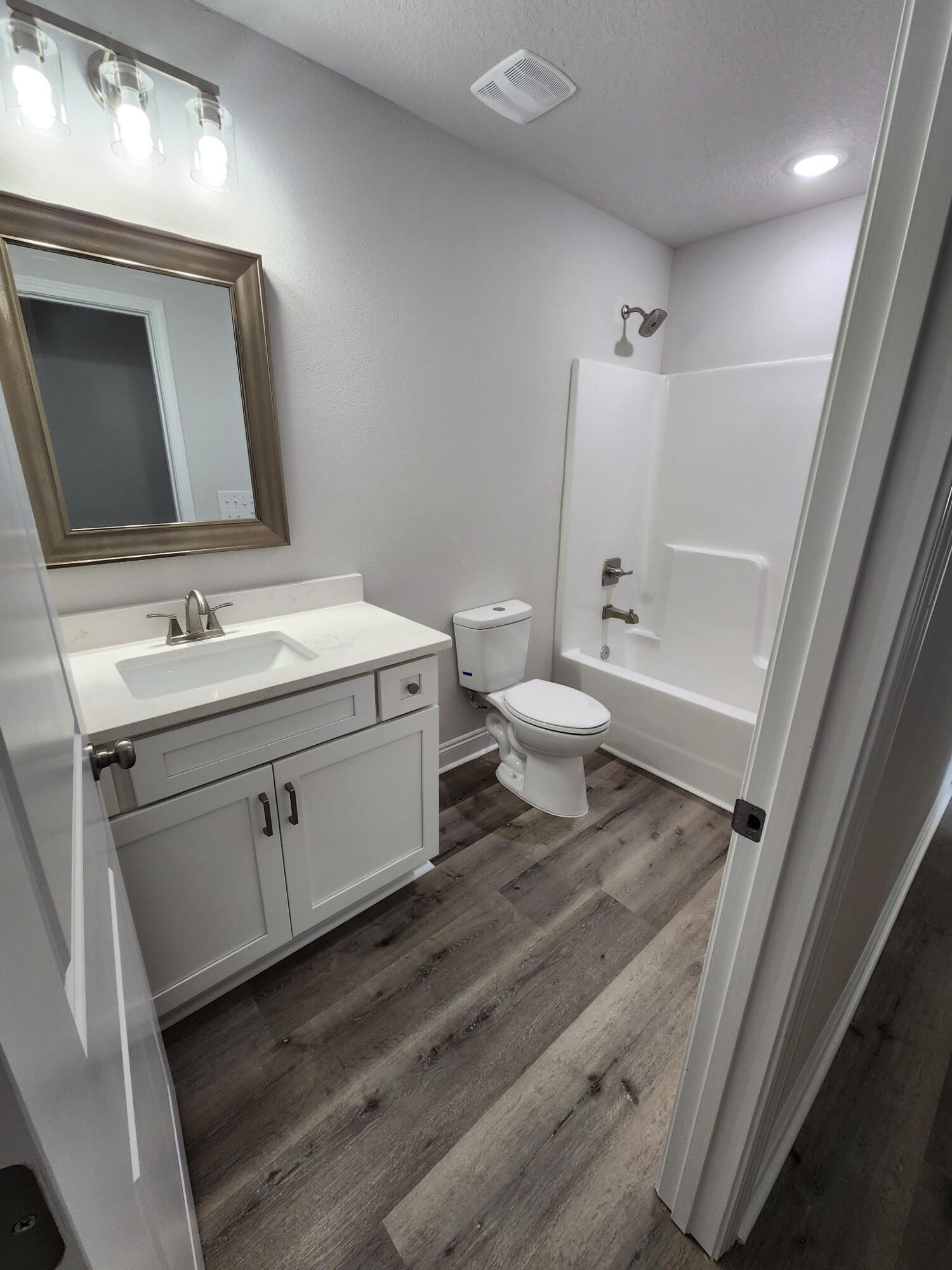 3168 Main Street Crestview, FL 32539 - Photo 15 of 18 a bathroom with a toilet a sink a mirror and vanity
