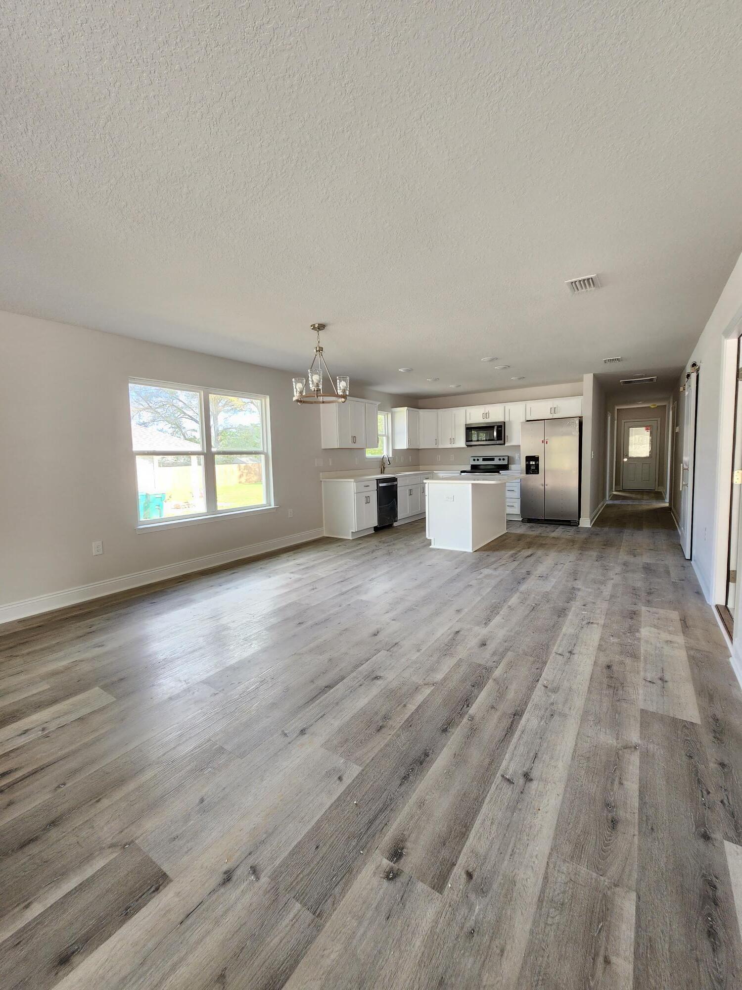 3168 Main Street Crestview, FL 32539 - Photo 4 of 18 a view of a big room with wooden floor and windows