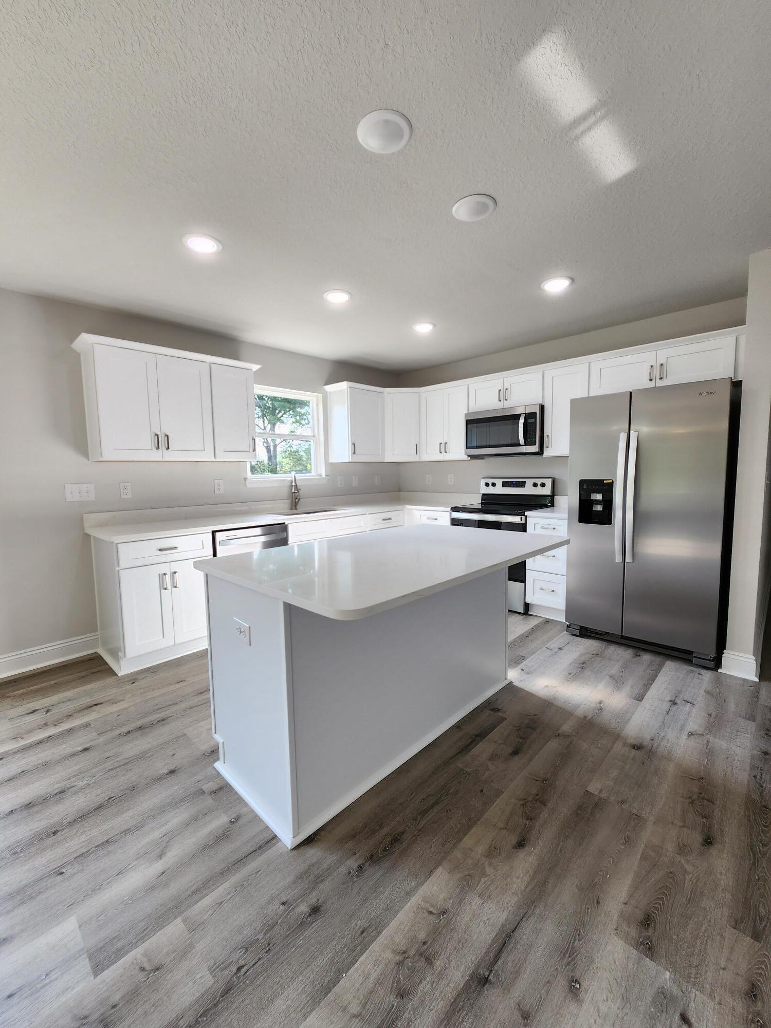 3168 Main Street Crestview, FL 32539 - Photo 5 of 18 a kitchen with stainless steel appliances granite countertop a stove a sink a refrigerator and a microwave