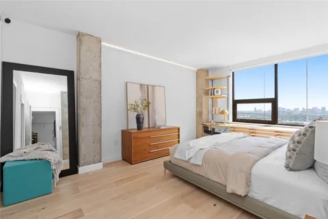 a bedroom with a bed and wooden floor