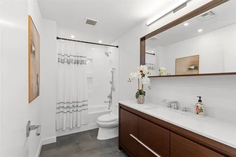 a view of an empty room with wooden floor and windows