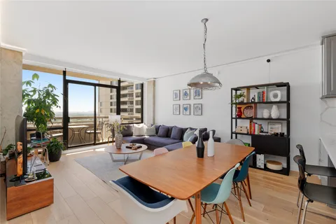 a living room with furniture a bookshelf and a window