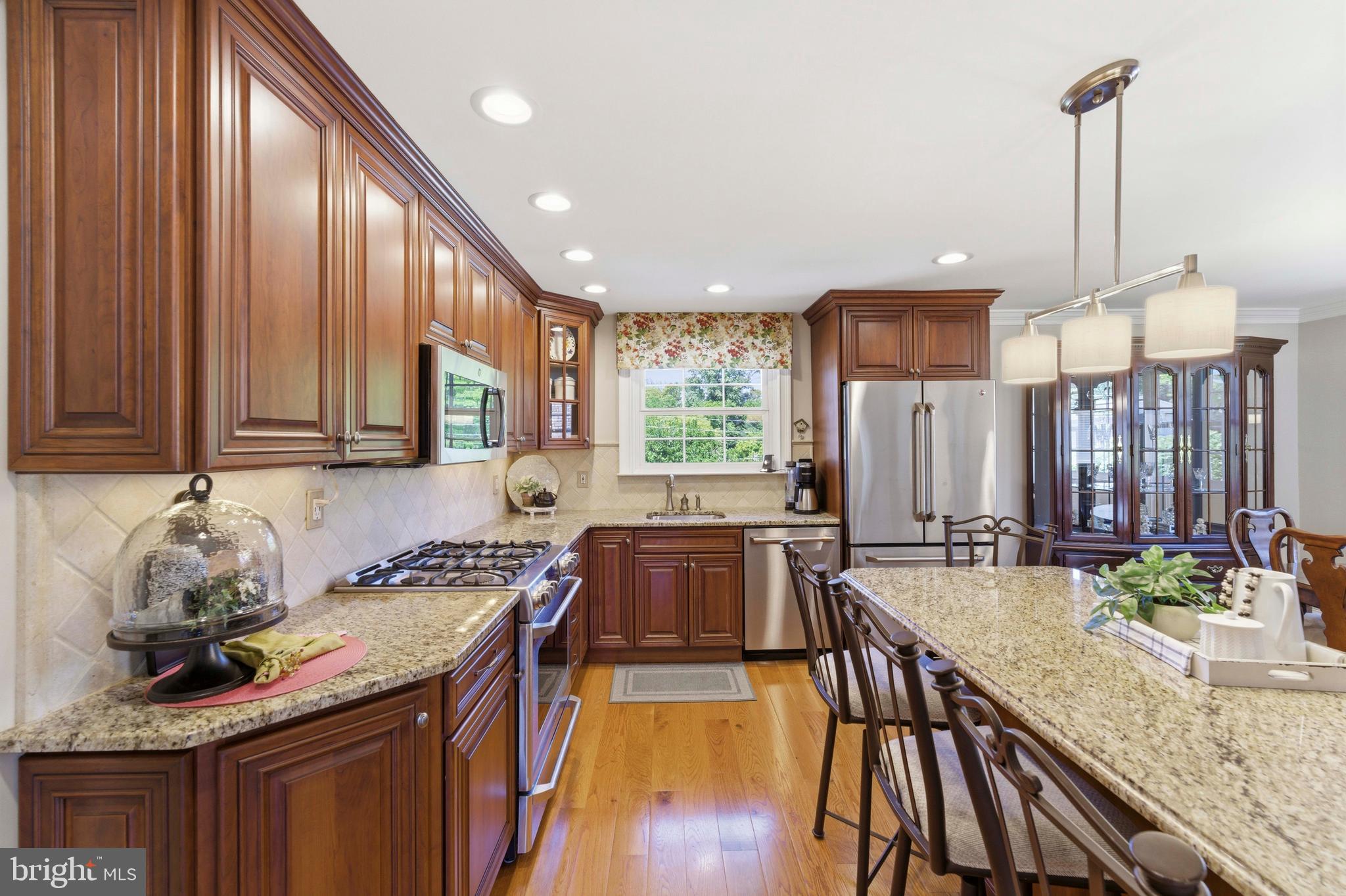 447 Maddock Road Springfield, PA 19064 - Photo 12 of 42 a kitchen with stainless steel appliances granite countertop a stove a sink and a wooden cabinets