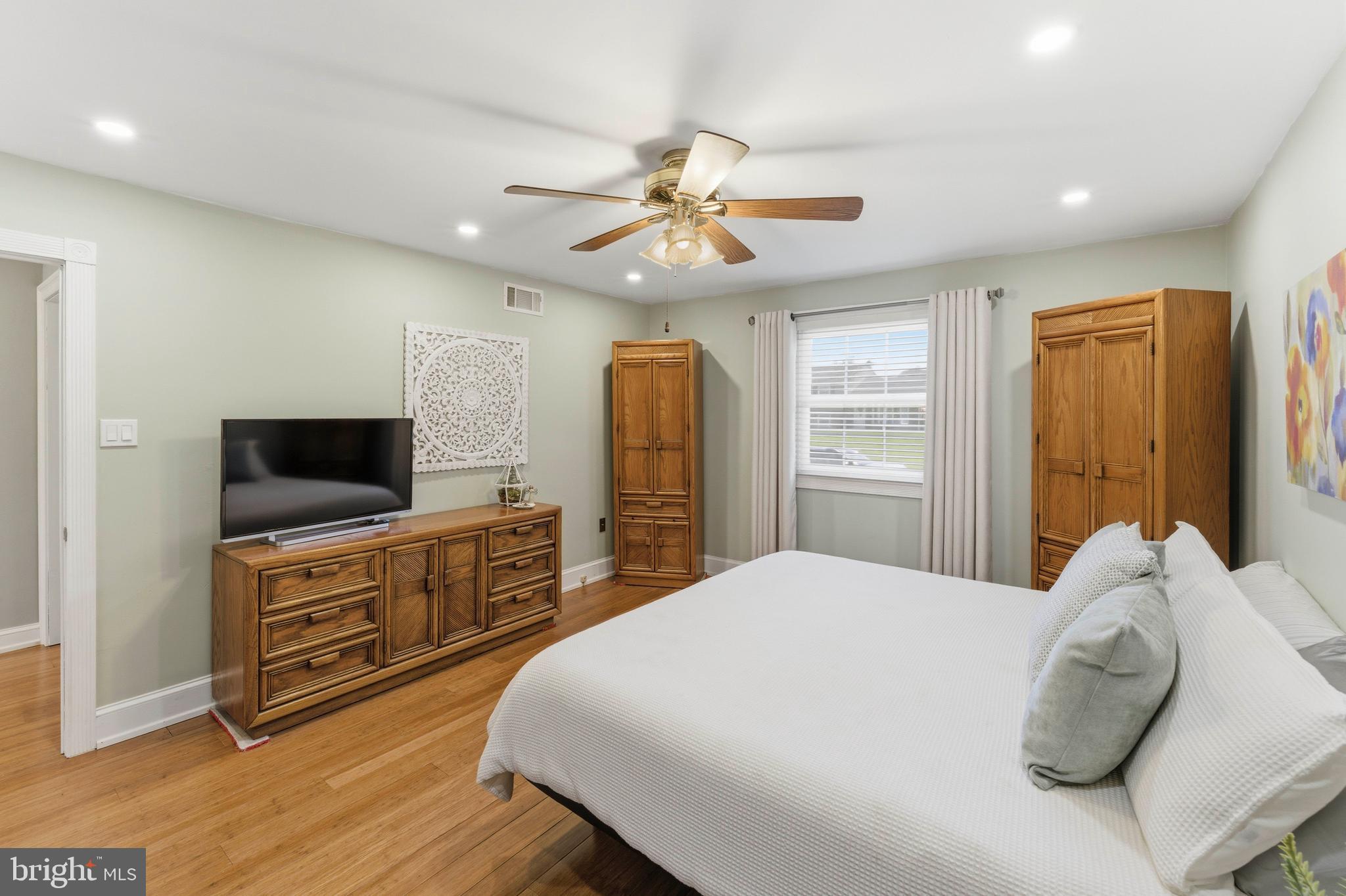 447 Maddock Road Springfield, PA 19064 - Photo 20 of 42 a bedroom with a large bed and a flat tv screen on dresser