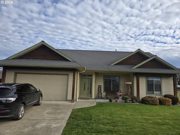 a front view of a house with a garden and yard