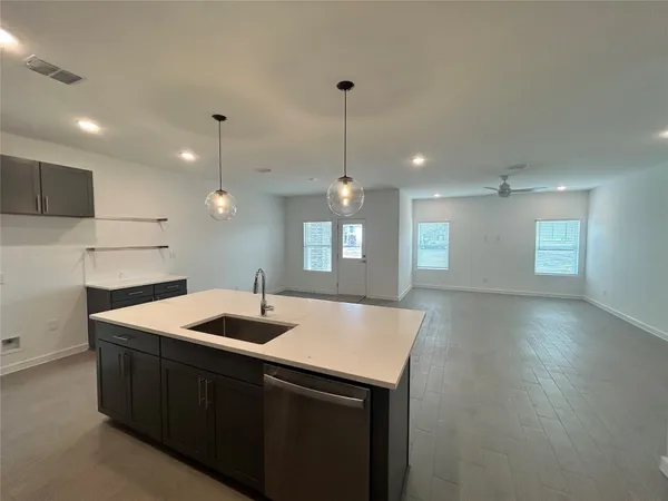 a kitchen with a sink chandelier and wooden floor