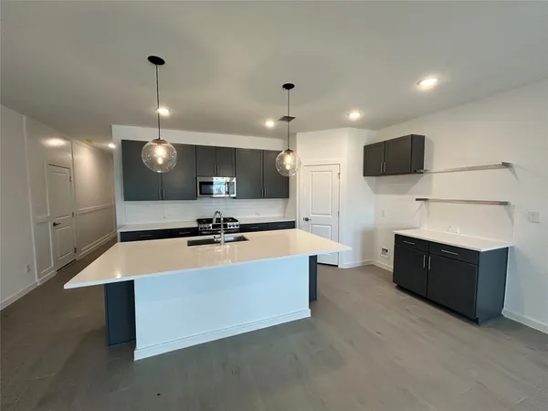 a large kitchen with stainless steel appliances a large counter top