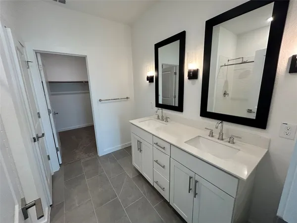 a bathroom with a double vanity sink and mirror