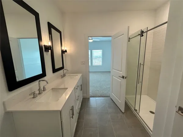 a bathroom with a sink a mirror a vanity and a shower