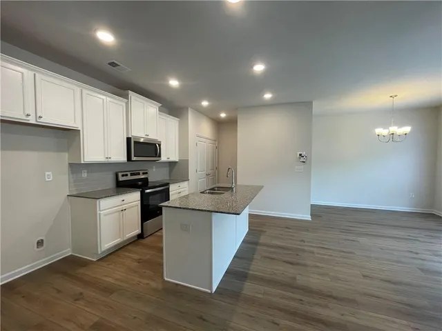 a kitchen with cabinets and wooden floor