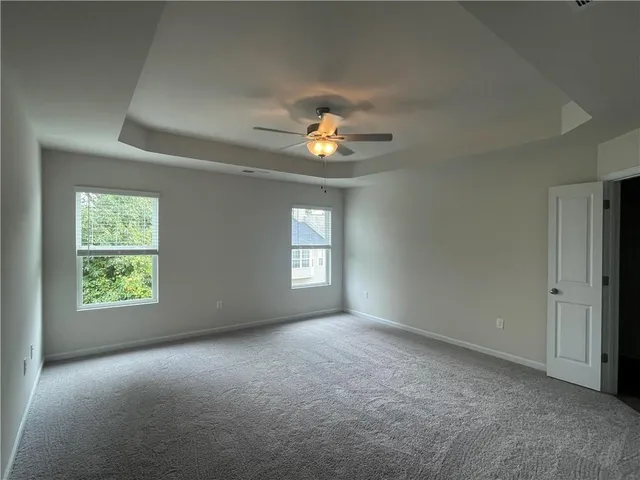 an empty room with a window and a ceiling fan
