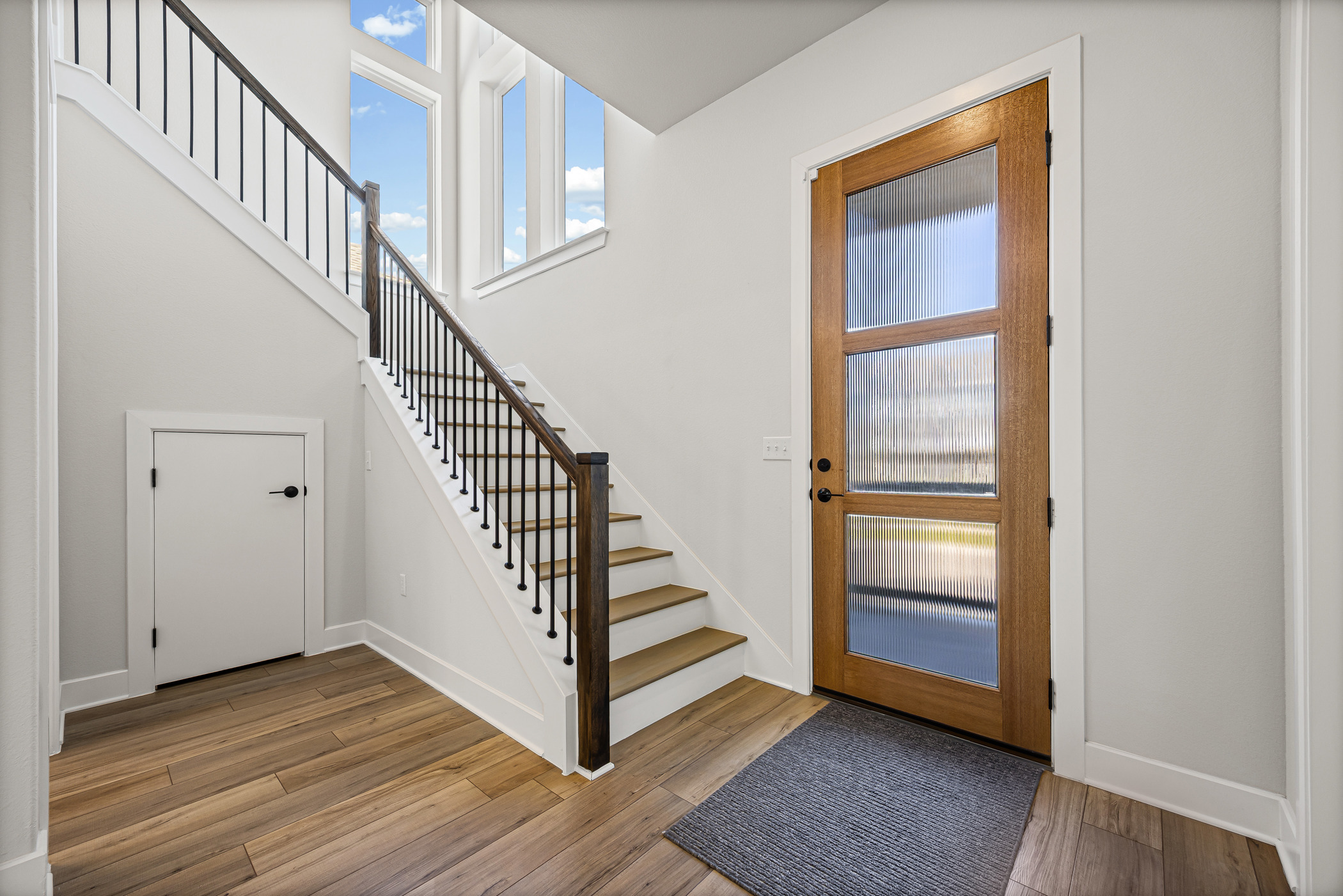 5806 Rangeland Road Austin, TX 78747 - Photo 18 of 34 A striking modern entryway showcases wood flooring and a grand staircase leading to upper levels.