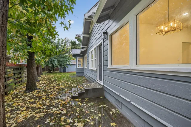 a house that is sitting in the grass with wooden fence
