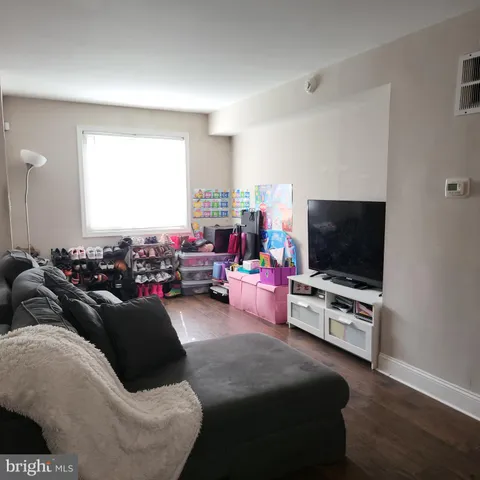 a kitchen with stainless steel appliances granite countertop a refrigerator a stove a sink dishwasher and a dining table with wooden floor