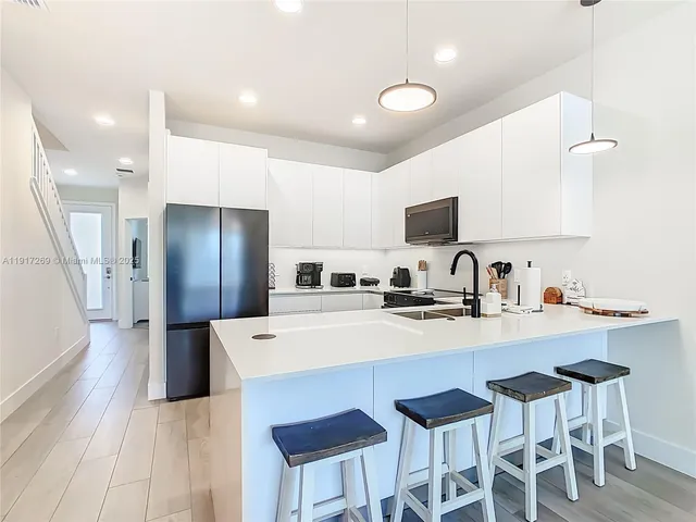 a kitchen with stainless steel appliances a refrigerator and a stove top oven
