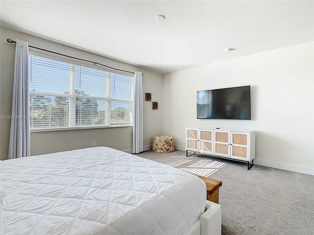 a bedroom with a bed and flat screen tv