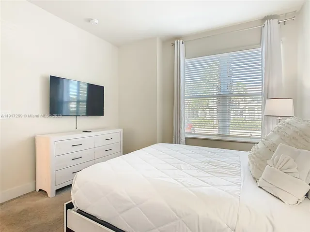 a bedroom with a bed and a flat tv screen in it
