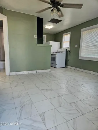 a view of a livingroom with a furniture a ceiling fan and window