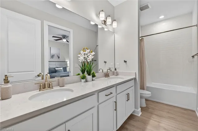 a bathroom with a double vanity sink mirror and toilet