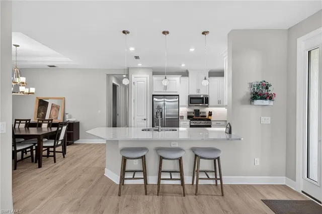 a kitchen with stainless steel appliances kitchen island granite countertop a dining table chairs and granite counter tops